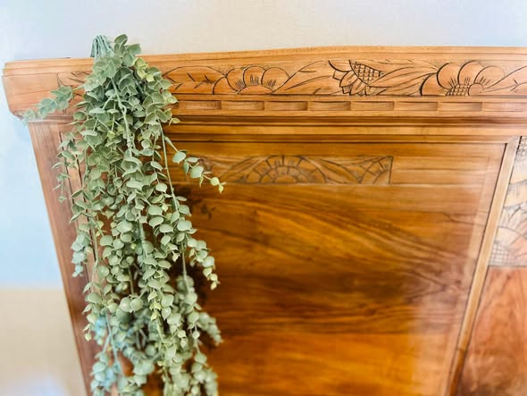 Détail de fleurs sculptées dans le bois d’une tête de lit ancienne
